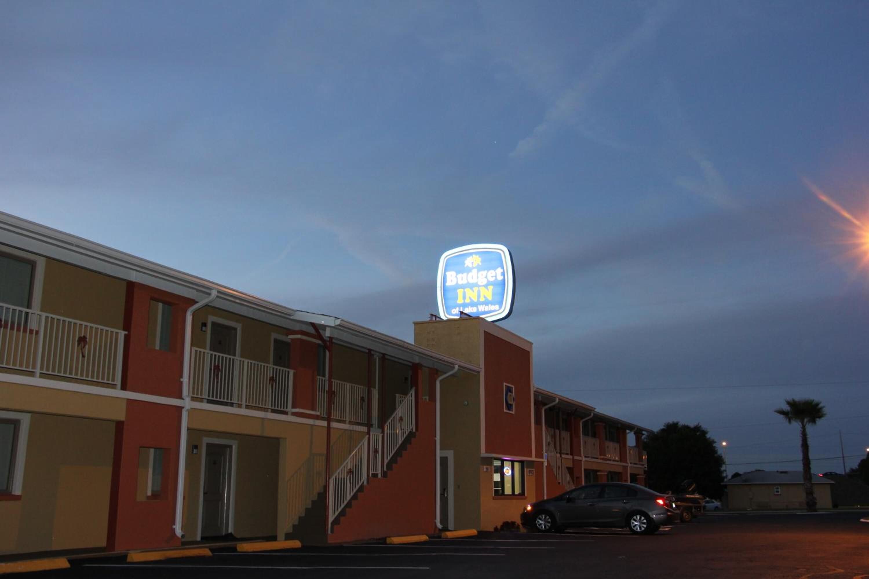 A motel with a prominent Budget Inn sign, multiple floors, and a parking lot.