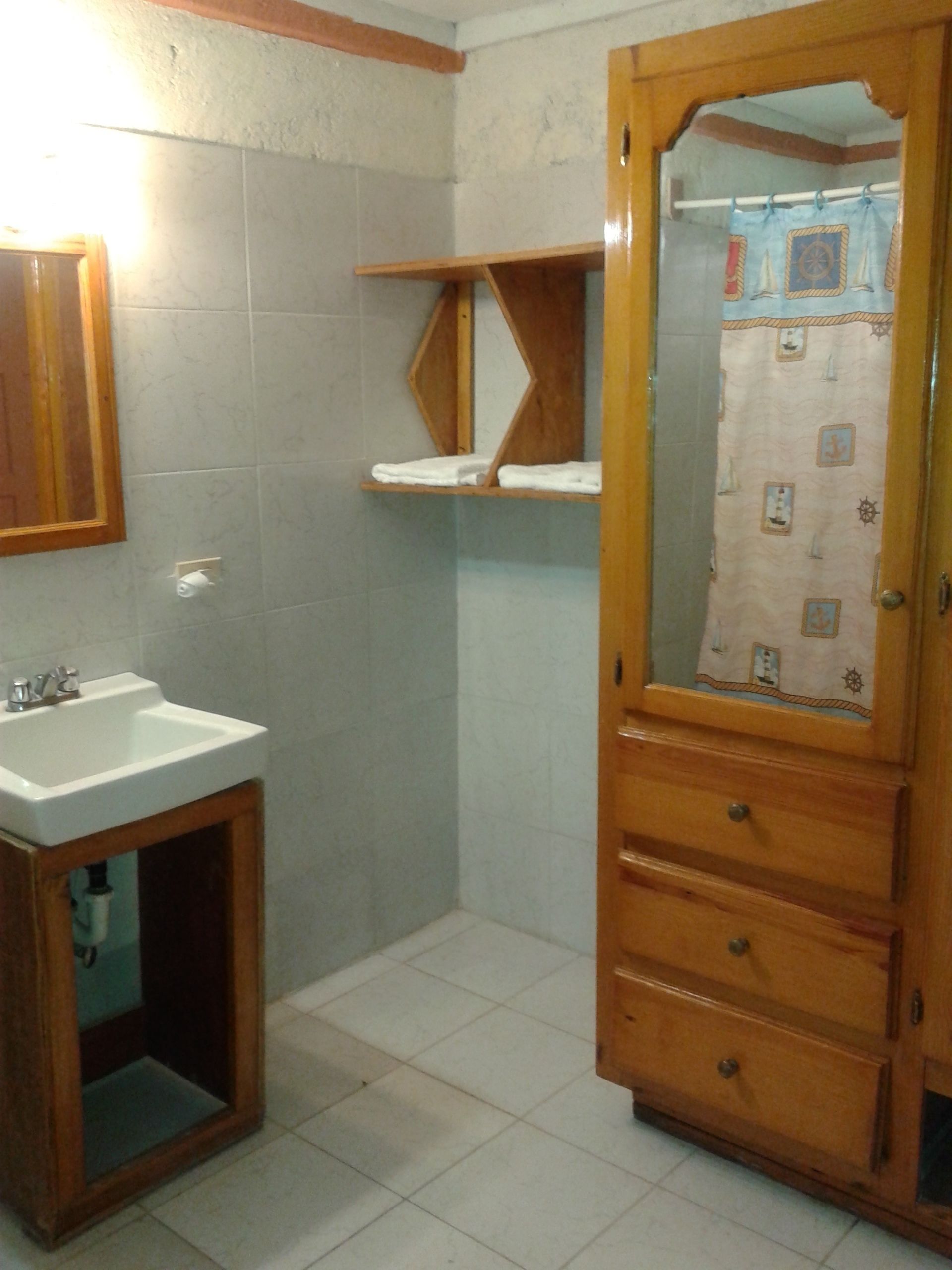 A bathroom with a wooden vanity, a sink, and a mirror.