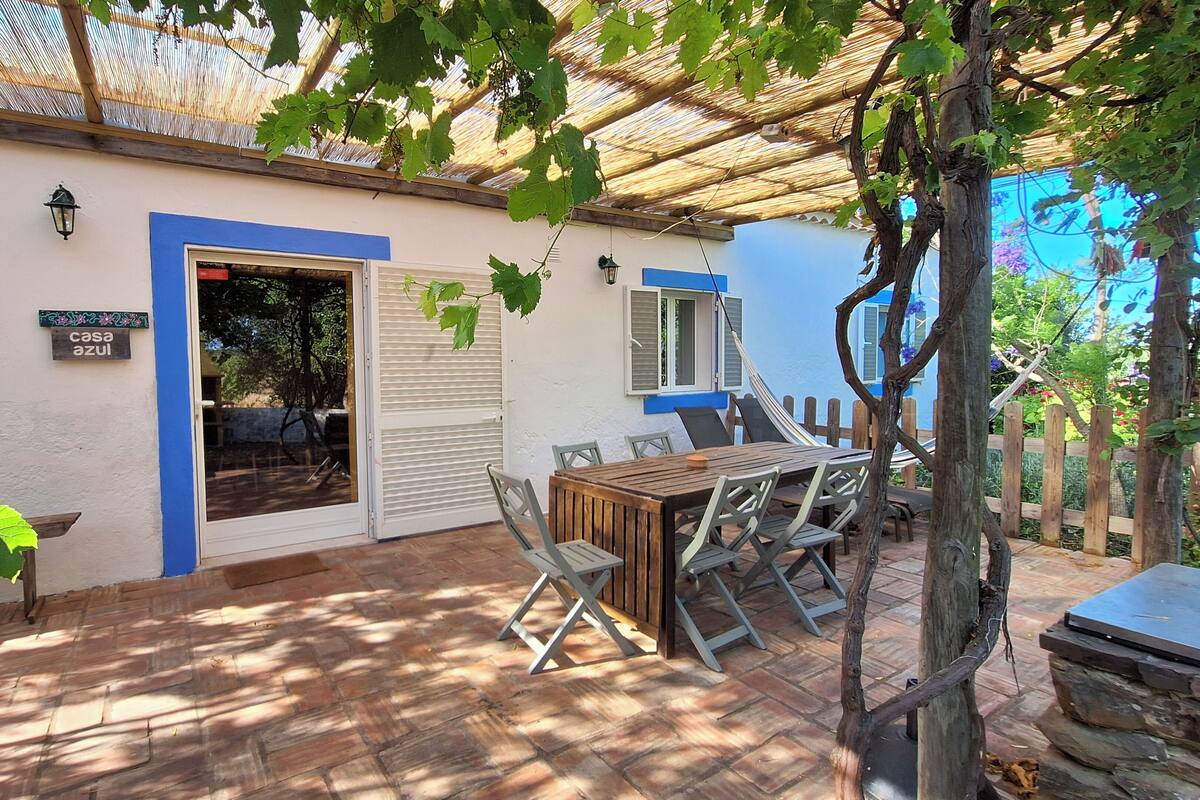 Un espace patio avec une table et des chaises en bois, une porte et une enseigne indiquant « Casa Azul ».