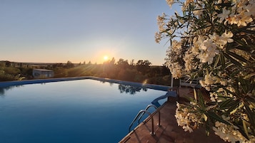 Una piscina al aire libre de temporada, sillones reclinables de piscina