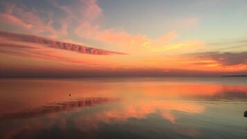 Un'acqua calma che riflette un cielo al tramonto con nuvole.