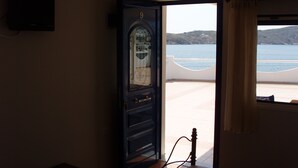 A bedroom with a bed, a dresser, and a view of the sea. - Cyclades Hotel Serifos (Serifos)