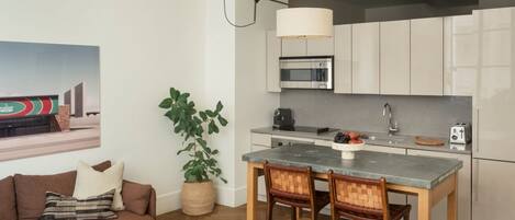A modern kitchen with a microwave, toaster, and a dining area with a table and chairs.