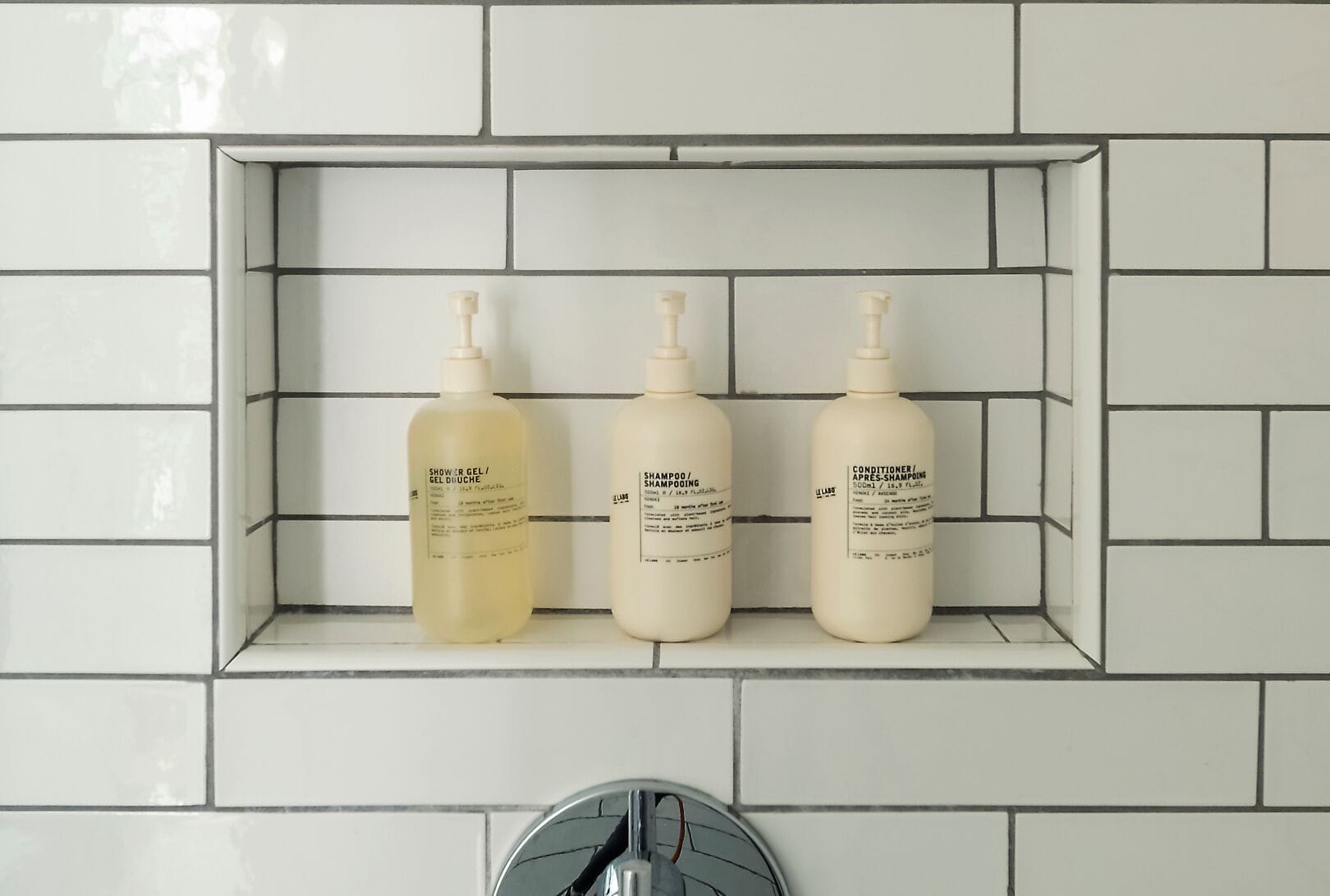 Een badkamerschaar met drie flessen toiletartikelen.