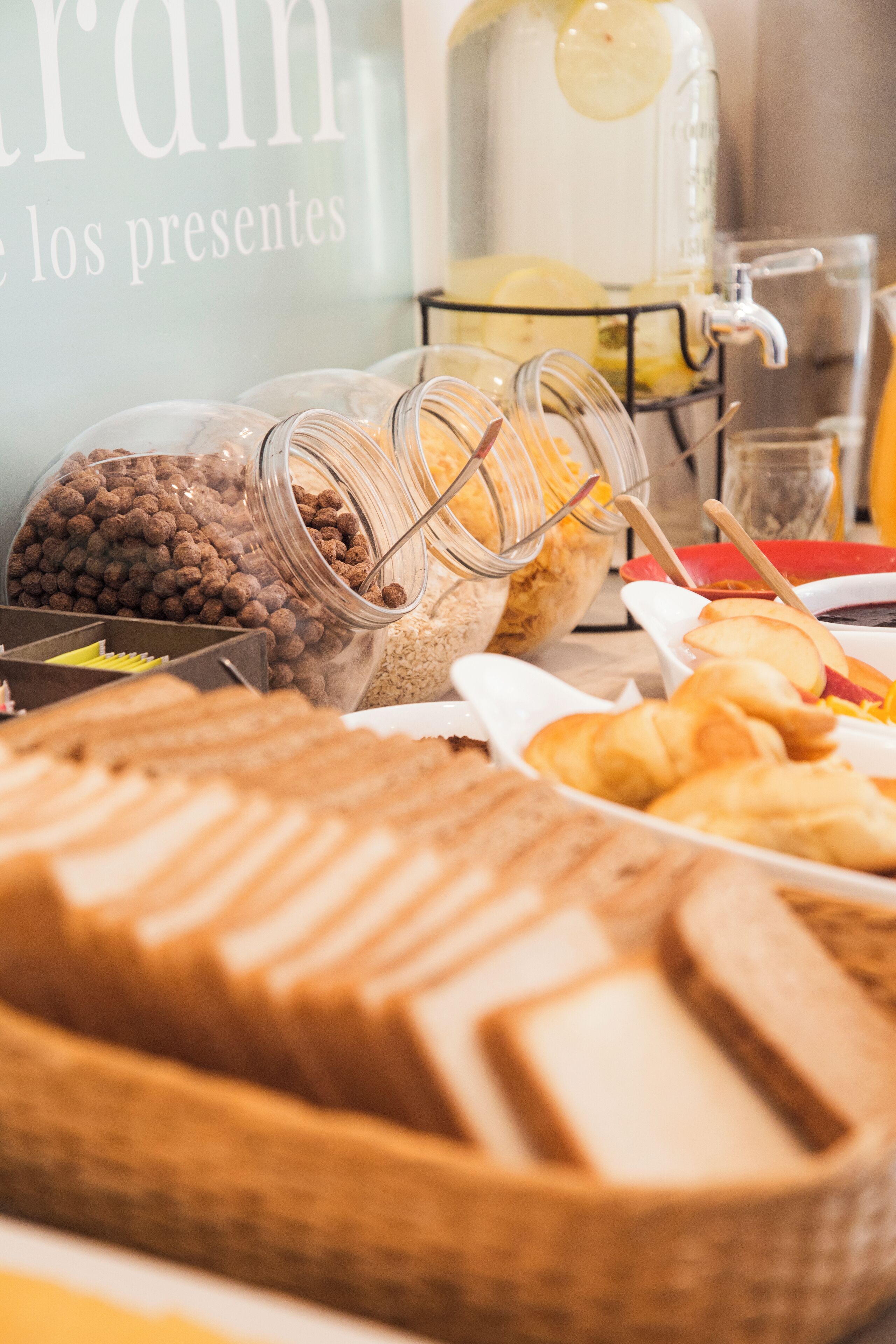 A buffet with various food items including pastries, fruits, and condiments.