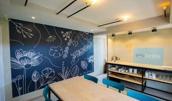 Un interior moderno con un mural floral, una recepción y una estación de café.