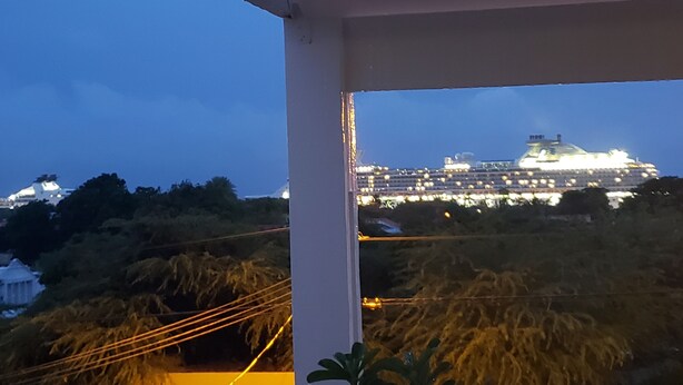 A balcony with a view of a cruise ship at night.