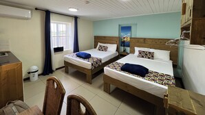 A room with two beds, a desk, and a chair.