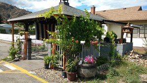 A house with a covered porch, potted plants, and a decorative horse statue. - Mount View Motel (Oliver)