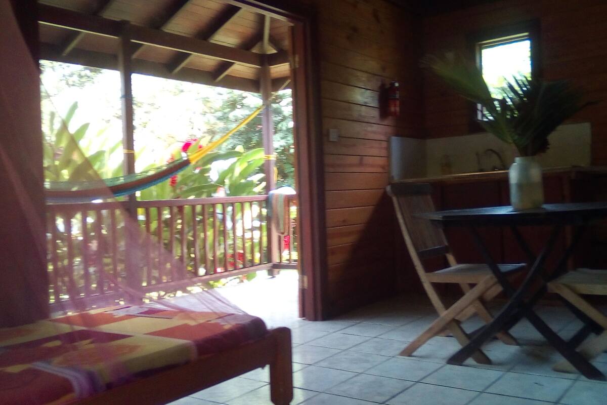 Eine Holzhütte mit Balkon, einem Esstisch und einem Stuhl.