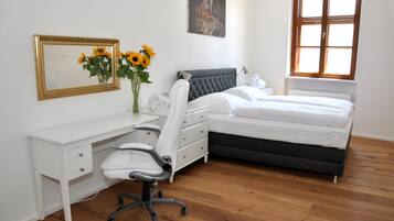 Un dormitorio con cama, escritorio, silla y ventana.