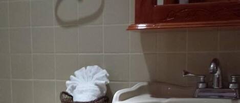 Une salle de bain avec des toilettes, un lavabo et un miroir au-dessus du lavabo.