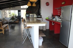 A kitchen with a central island, a refrigerator, a microwave, and a gas stove. - Vista Sunzal Bungalow (Tamanique)