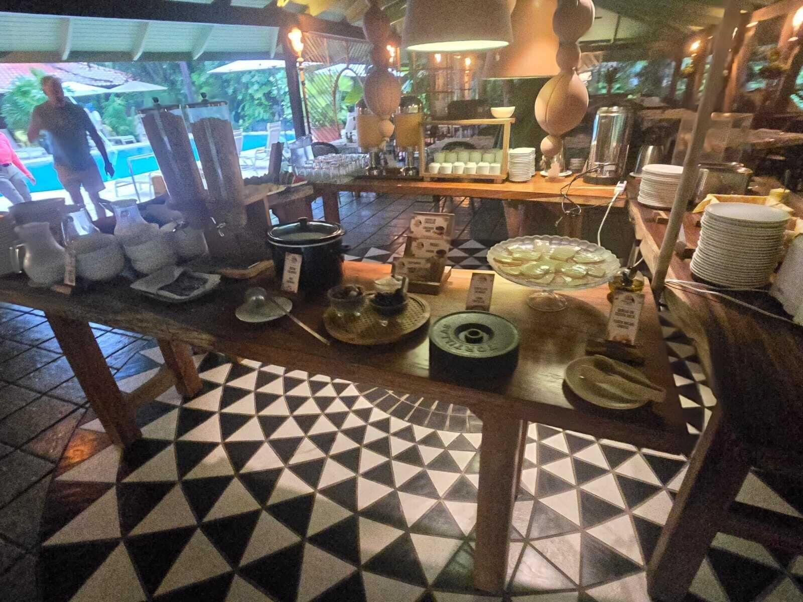 Ein reichhaltiges Buffet mit verschiedenen Speisen und Geschirr auf einer Theke, umgeben von einem gefliesten Boden.