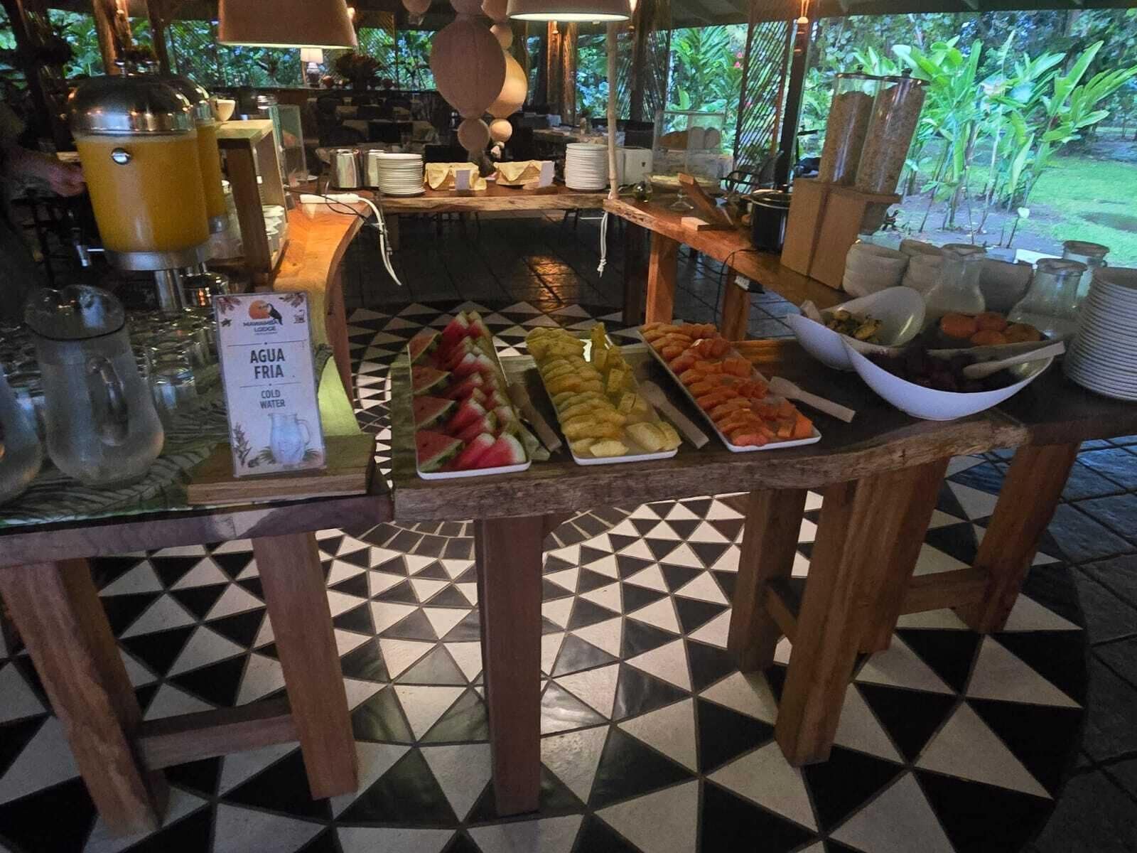 Una mesa de bufé con diferentes opciones de comida y un cartel que indica agua fría.