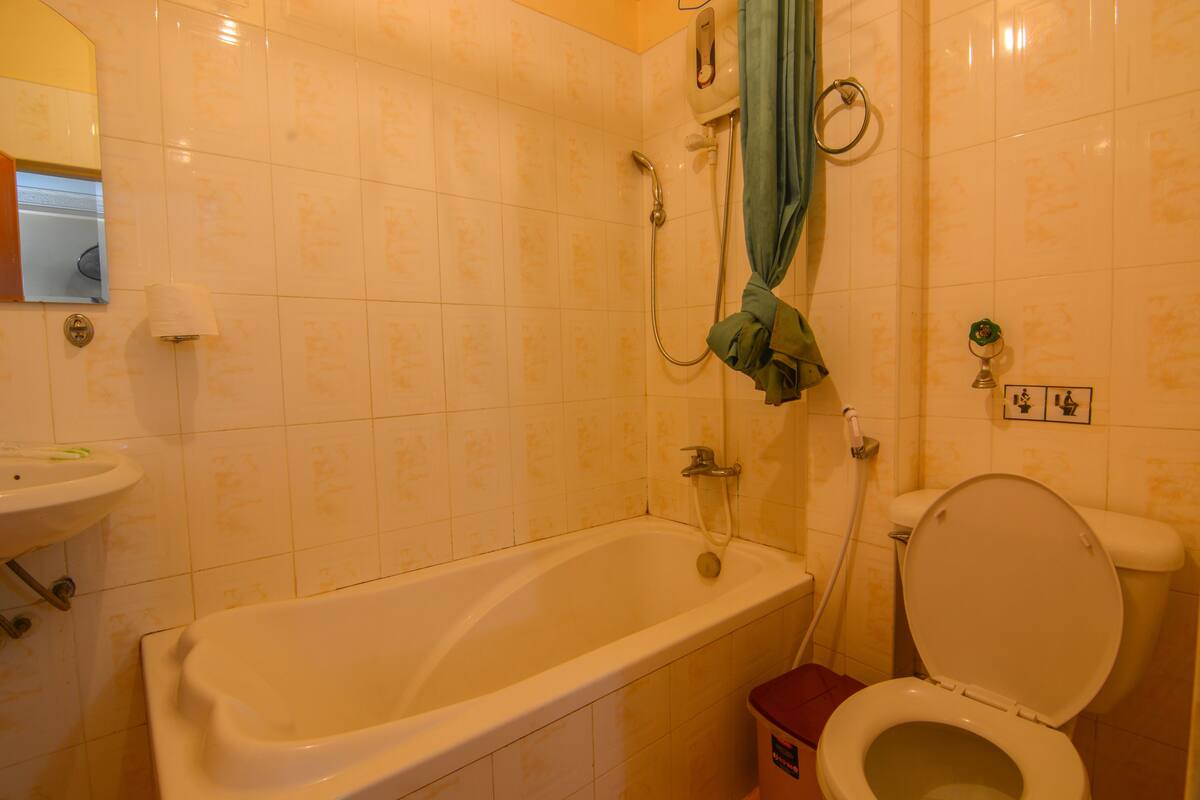 A bathroom with a bathtub, toilet, and a sink.