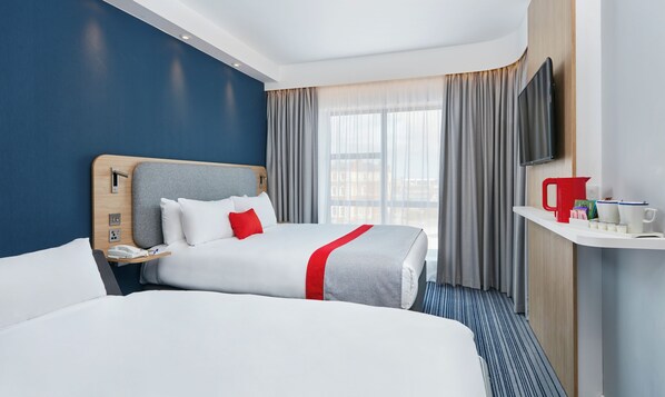A hotel room with two beds, a TV, a bedside table with a phone, and a window with curtains. - Holiday Inn Express Grimsby by IHG (Grimsby)