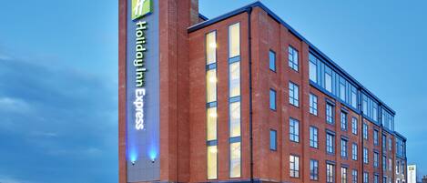 A Holiday Inn Express hotel with a brick facade, large windows, and a visible entrance.
