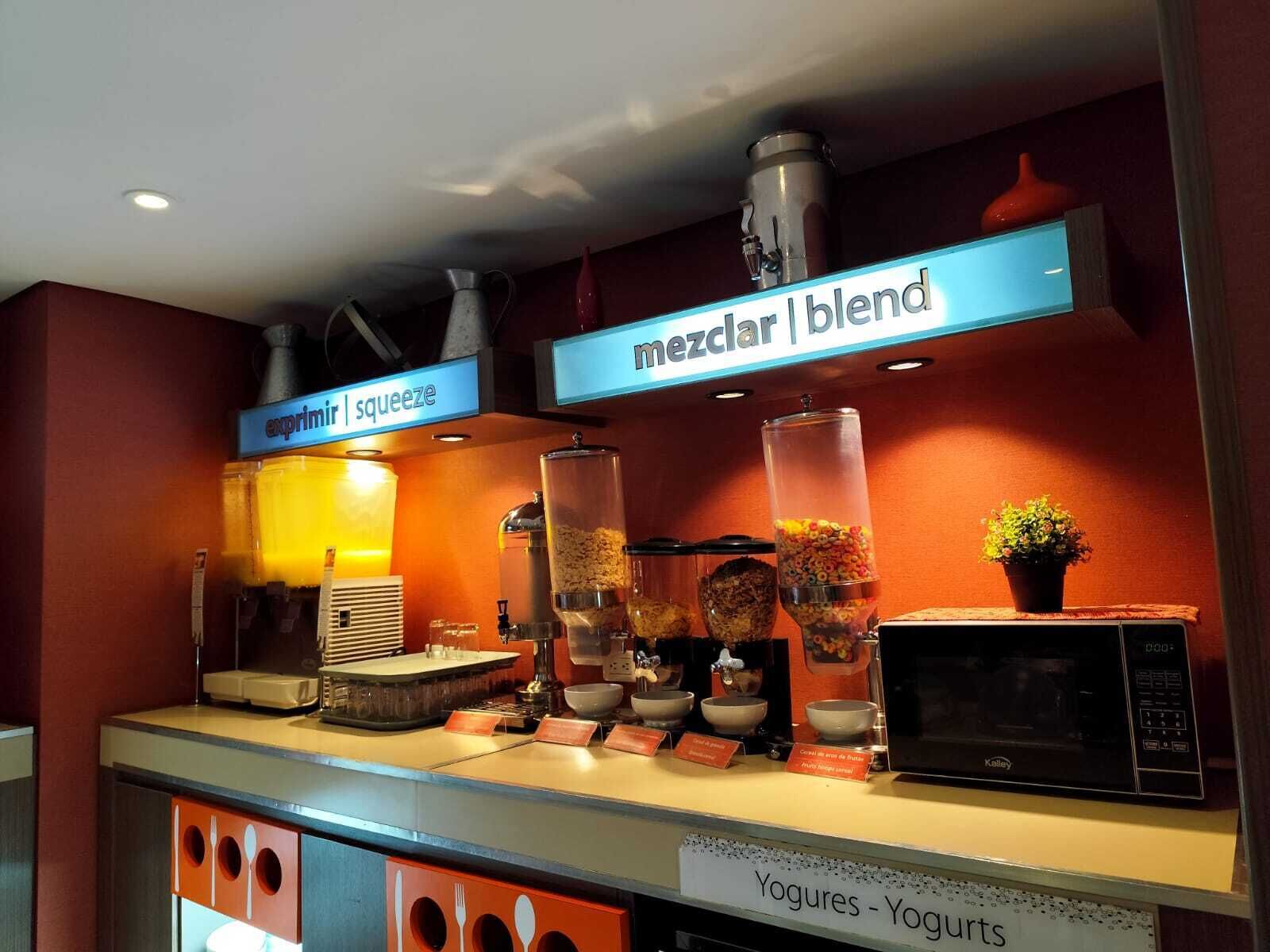 A breakfast bar with a variety of food items and a microwave.