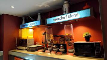 A breakfast bar with a variety of food items and a microwave.