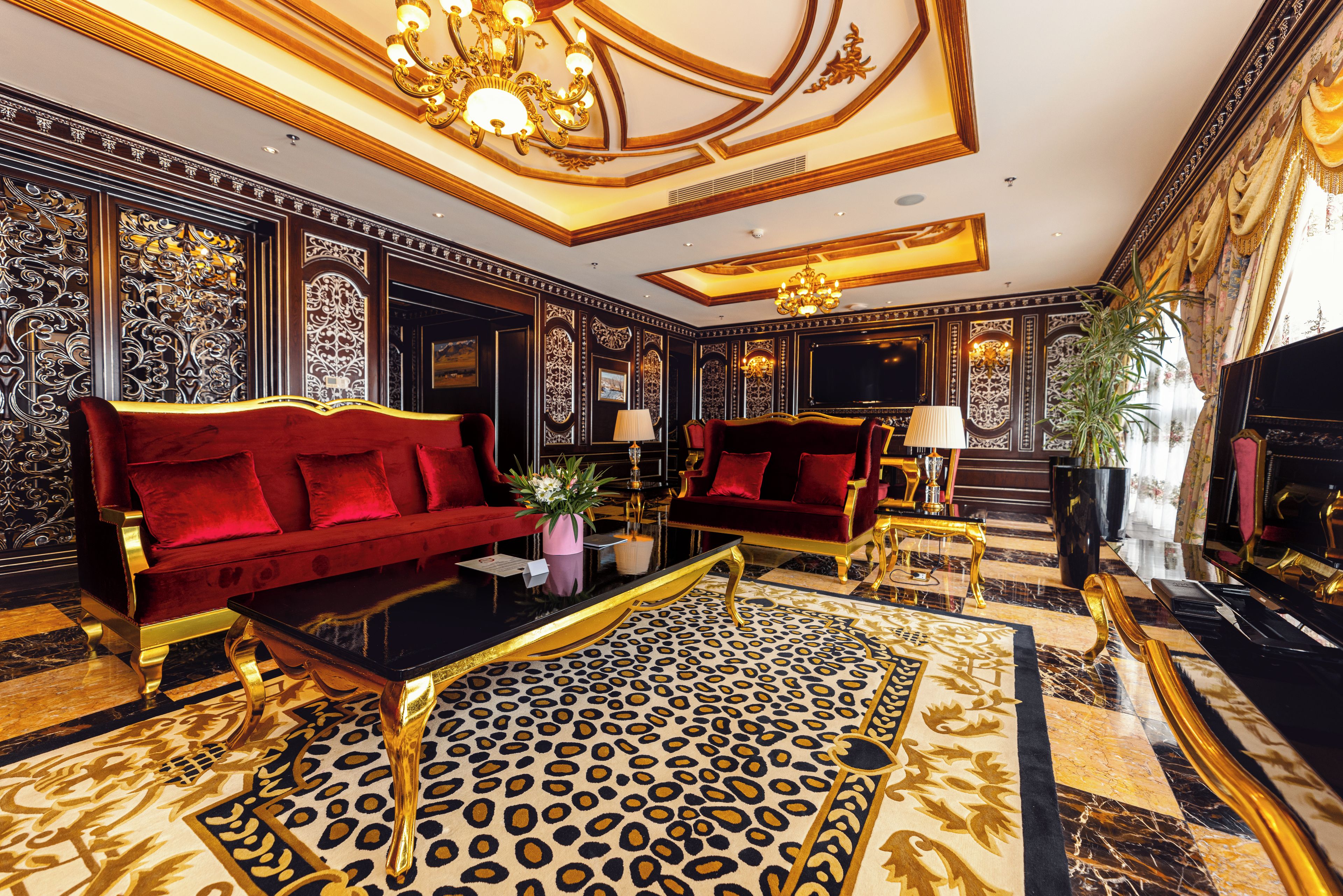 Una habitación lujosa con un sofá rojo, una alfombra de estampado de leopardo y un piano de cola.