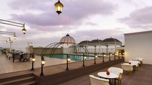 A rooftop bar with a pool, outdoor seating, and a gazebo. - Ramada Plaza by Wyndham Chandigarh Zirakpur (Dera Bassi)
