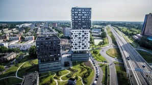 A modern building complex with a mix of residential and commercial structures, surrounded by green spaces and a highway. - Leonardo Hotel Groningen Stadspark (Groningen)