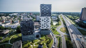 A modern building complex with a mix of residential and commercial structures, surrounded by green spaces and a highway. - Leonardo Hotel Groningen Stadspark (Groningen)