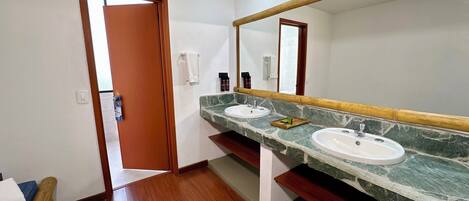 A bathroom with two sinks, a mirror, and a wooden door.