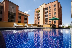 Una piscina al aire libre, sillones reclinables de piscina