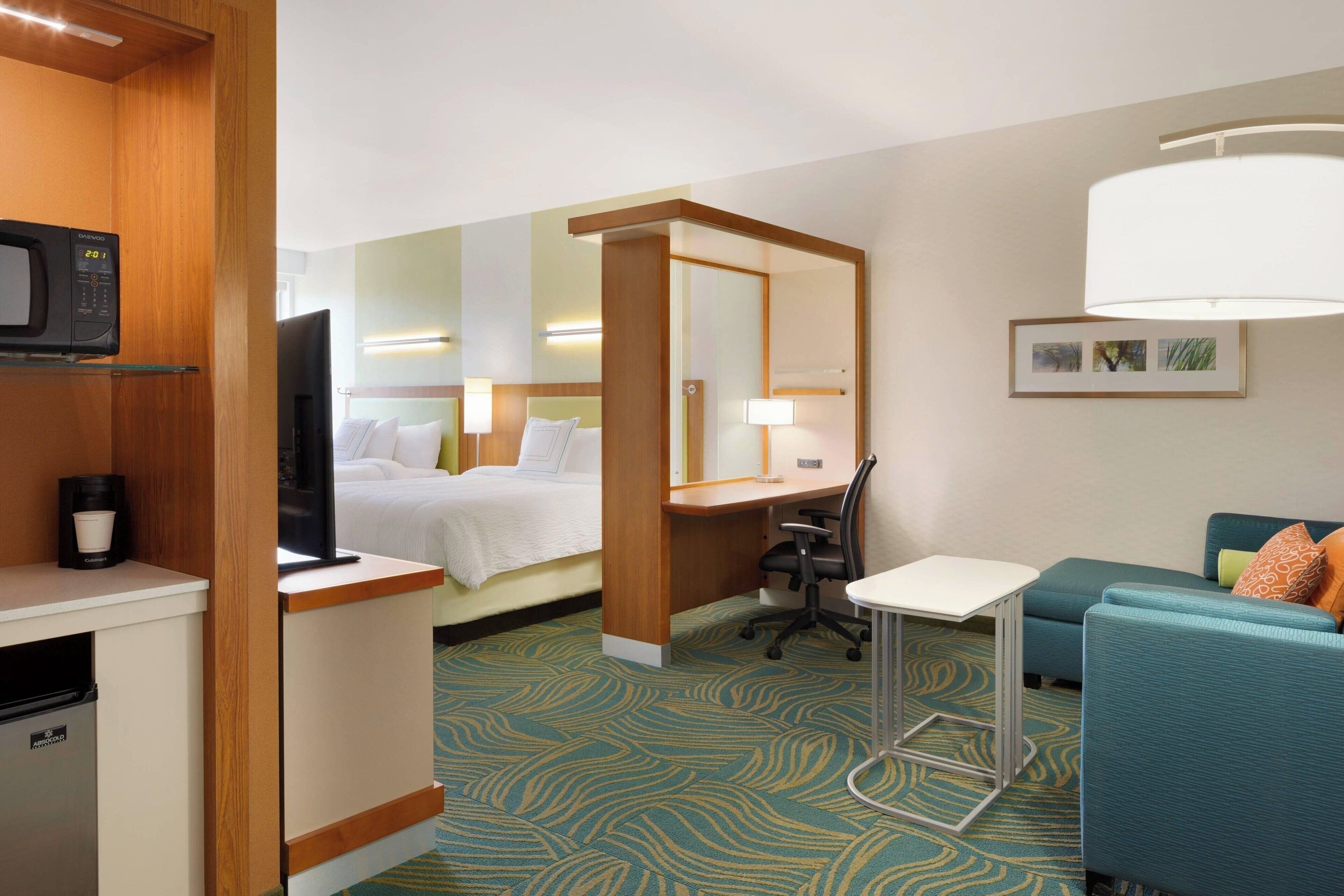 Ein Hotelzimmer mit Bett, Schreibtisch, Stuhl und einem kleinen Tisch.