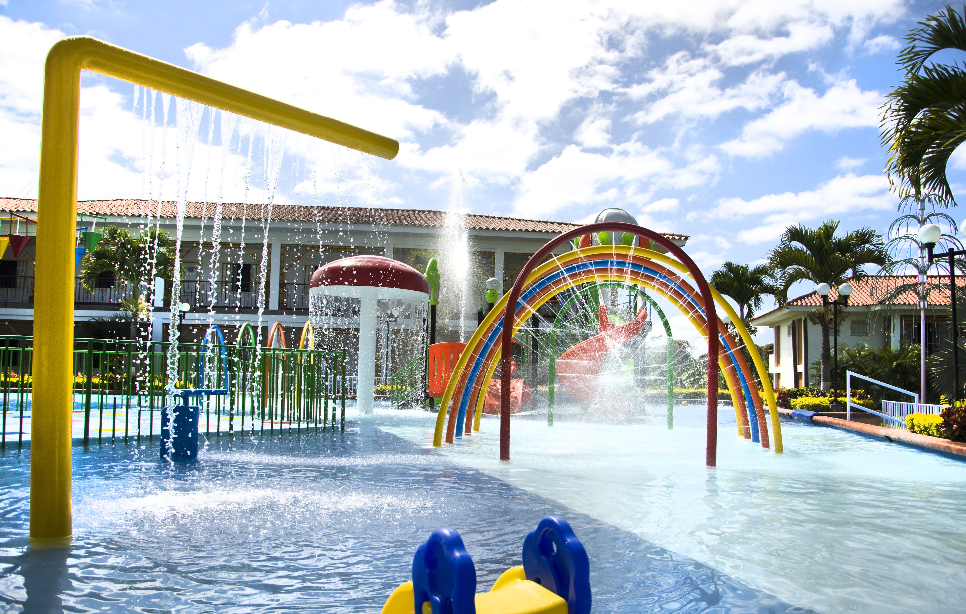 Un parco acquatico con uno scivolo a forma di arcobaleno e una fontana d'acqua.