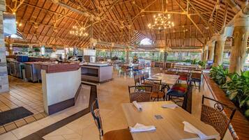 A spacious restaurant with a high wooden ceiling and natural light. Tables and chairs are arranged for dining.
