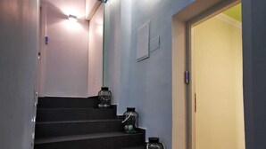 A staircase with a blue ceiling, white walls, and a door at the top. - Central Boutique Hotel (Jerusalem)