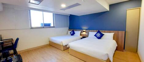 Una habitación de hotel con dos camas, un escritorio y una silla.