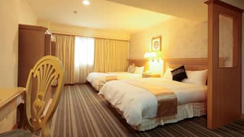 A hotel room with two beds, a wooden chair, a desk, and a lamp.