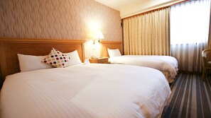 A hotel room with two beds, a nightstand with a lamp, a telephone, and a chair. - Tainan Cambridge Hotel (Tainan)