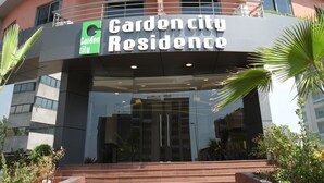 A multi-story residential building with balconies, a sign reading "Garden City Residence," and a modern architectural design. - Garden City Residence (Dekwaneh)