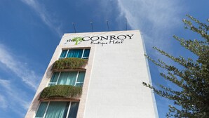 A hotel named 'Conroy Boutique Hotel' with a clear blue sky in the background.