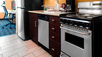 Una cocina moderna con electrodomésticos de acero inoxidable, lavavajillas y cafetera.