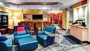 A hotel lobby with blue seating, a bar area, and a television screen. - Towneplace Suites Bakersfield West (Bakersfield)