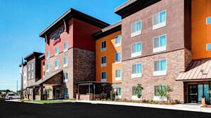A multi-story hotel with a stone facade, multiple windows, and a sign reading "TownePlace Suites." - Towneplace Suites Bakersfield West (Bakersfield)