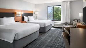 A hotel room with two beds, a desk, a chair, a TV, and a window with curtains. - Towneplace Suites Salt Lake City-West Valley (West Valley City)