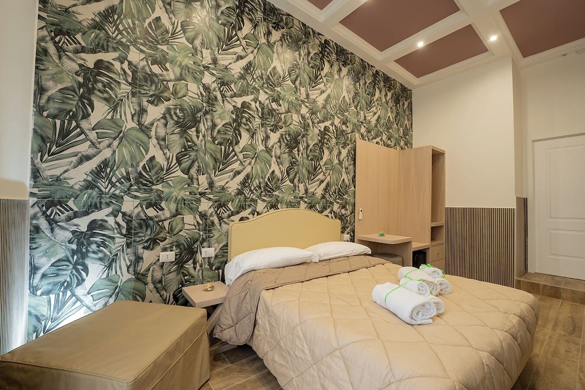Une chambre à coucher avec un lit, une table de chevet, une armoire en bois et une porte menant à la salle de bain.