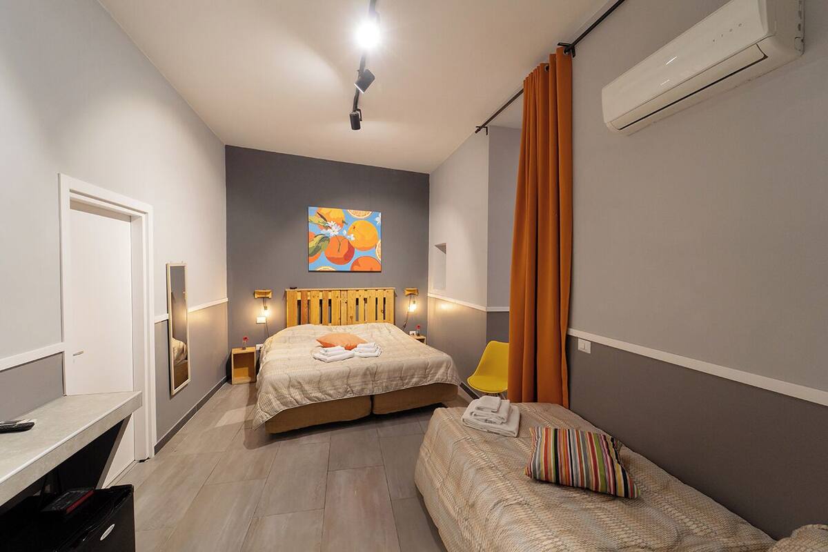 Une chambre à coucher avec un lit, un bureau, une chaise et un tableau au mur.