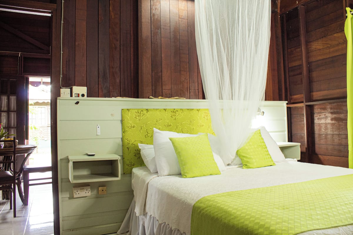 A bed with a canopy, a bedside table, and a nightstand.