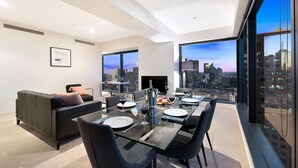 A modern dining area with a city view, a sofa, and a fireplace. - Southbank Apartments - Eureka Tower (Southbank)