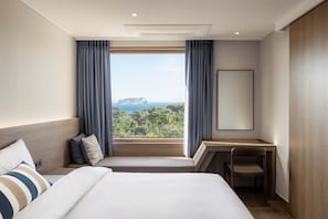 Una camera d'albergo con un letto grande, una scrivania e vista su un paesaggio montuoso.