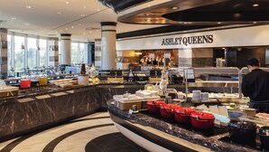 A hotel lobby with a buffet area, a store named "Ashley Queens," and a large window providing a view of the outdoors. - Kensington Resort Seogwipo (Seogwipo)