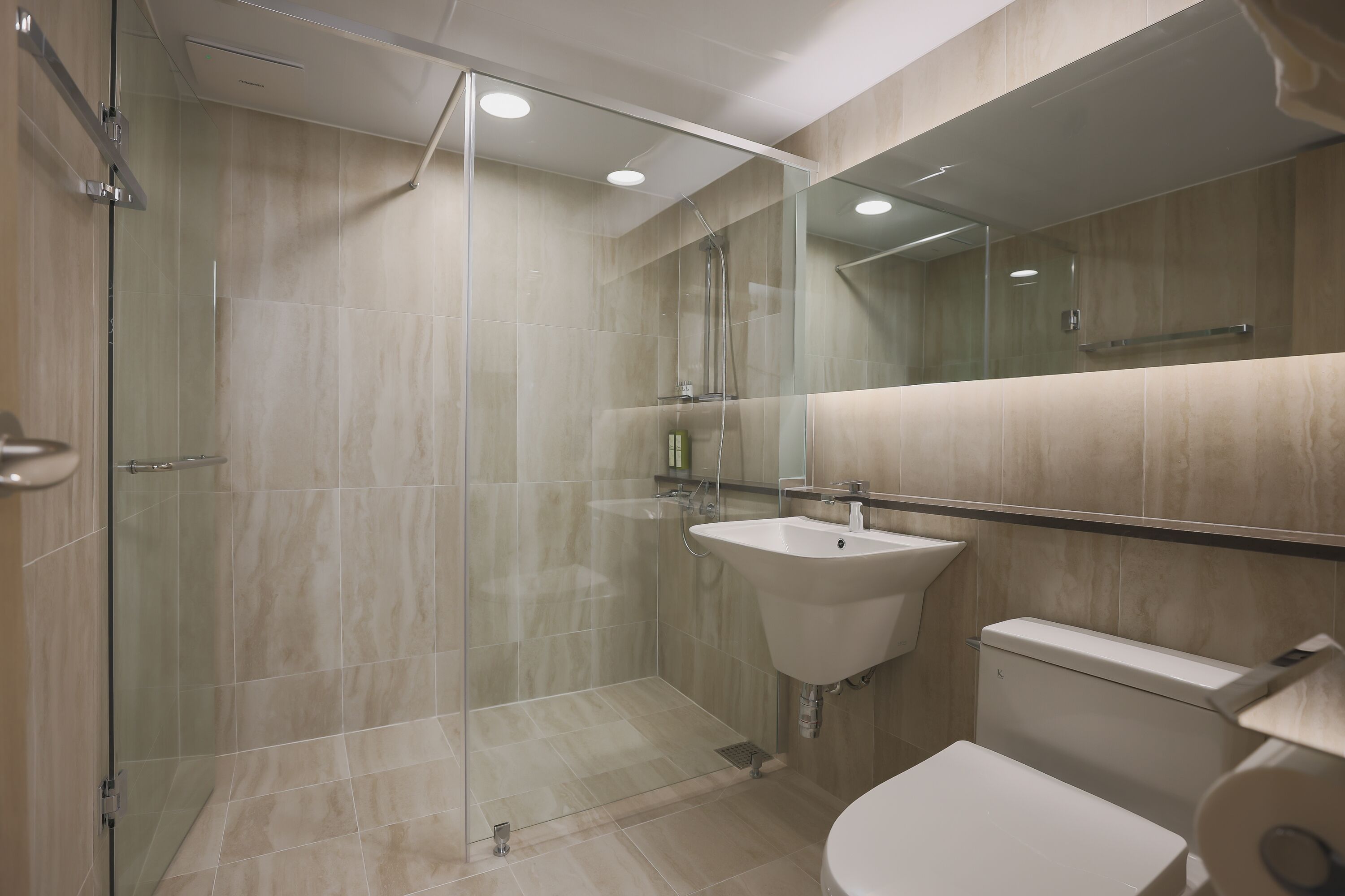 A modern bathroom with a glass-enclosed shower, a sink, and a toilet.